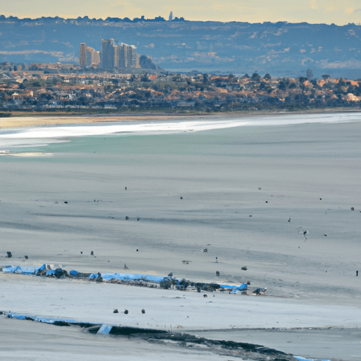 נוף פנורמי של קו החוף של סן דייגו, עם גולשים רוכבים על הגלים